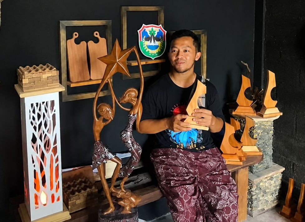 Kusuma Hadi Purnawan dari Komunitas Ros Timur Indonesia saat memegang piala Juara Umum Porseni Kabupaten Pacitan 2026 bermotif Wayang Beber.
