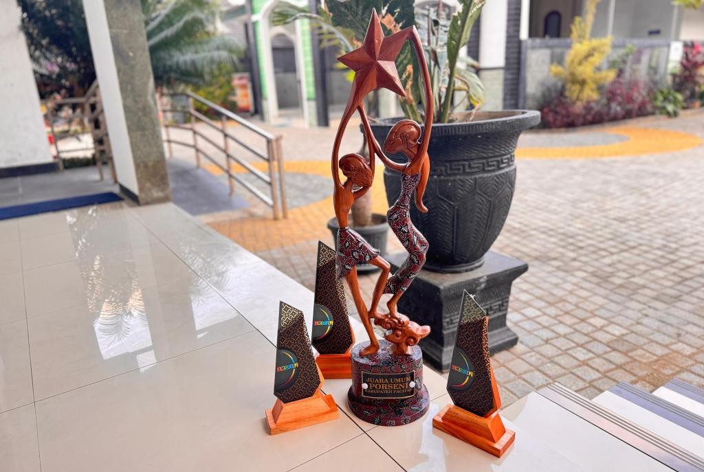 Piala Juara Umum Porseni Kabupaten Pacitan 2026 terbuat dari kayu bermotif Wayang Beber dan batik pace setinggi 90 cm karya Komunitas Ros Timur Indonesia.