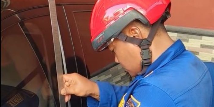 Petugas Damkar Pacitan mengevakuasi kunci mobil Wuling Air EV yang tertinggal di dalam kendaraan menggunakan alat taktis.