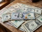 Ilustrasi pergerakan grafik melemahnya mata uang rupiah terhadap lembaran uang dolar Amerika Serikat.