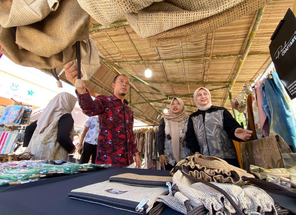 Kepala Dikuperin Pacitan Muhammad Ali Mustofa didampingi pengurus Komunitas Kriya Pacitan sedang mengamati dan mengecek produk kerajinan lokal di salah satu stan UMKM Pacitan Art Market 2026.