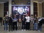 penyerahan-piala-juara-esport-kapolres-cup-pacitan-2026 Kapolres Pacitan berfoto bersama para pemenang Turnamen E-Sport Kapolres Cup 2026 di atas panggung sambil memegang piala.