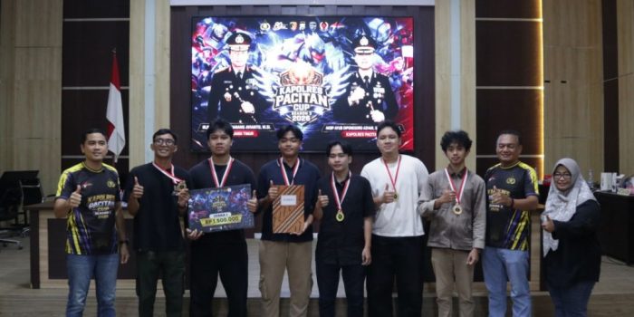 Kapolres Pacitan berfoto bersama para pemenang Turnamen E-Sport Kapolres Cup 2026 di atas panggung sambil memegang piala.