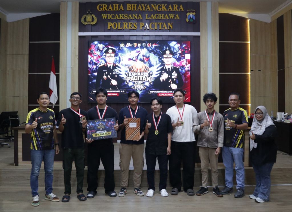 penyerahan-piala-juara-esport-kapolres-cup-pacitan-2026 Kapolres Pacitan berfoto bersama para pemenang Turnamen E-Sport Kapolres Cup 2026 di atas panggung sambil memegang piala.