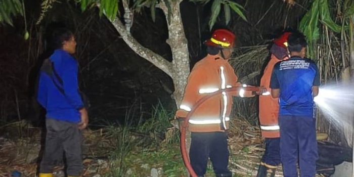 Petugas Damkar Pacitan memadamkan api pada kebakaran lahan kosong di Kelurahan Sidoharjo akibat pembakaran sampah.