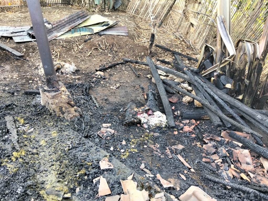 Petugas Damkar Pacitan memadamkan sisa api pada puing-puing rumah yang terbakar di Desa Punung.