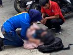 Warga setempat memberikan pertolongan pertama kepada korban kecelakaan lalu lintas di lokasi kejadian.