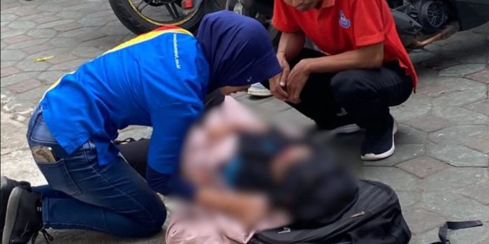 Warga setempat memberikan pertolongan pertama kepada korban kecelakaan lalu lintas di lokasi kejadian.