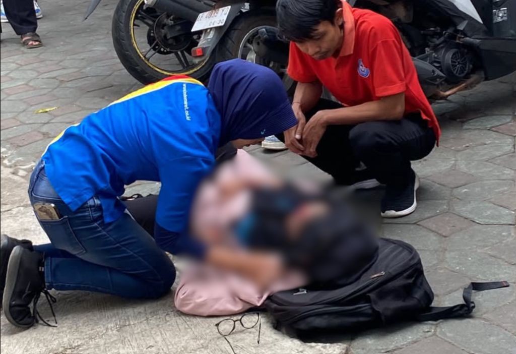 Warga setempat memberikan pertolongan pertama kepada korban kecelakaan lalu lintas di lokasi kejadian.