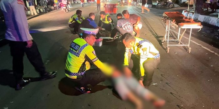 Petugas kepolisian meninjau lokasi kecelakaan lalu lintas yang melibatkan motor warga dan kendaraan dinas di Pacitan