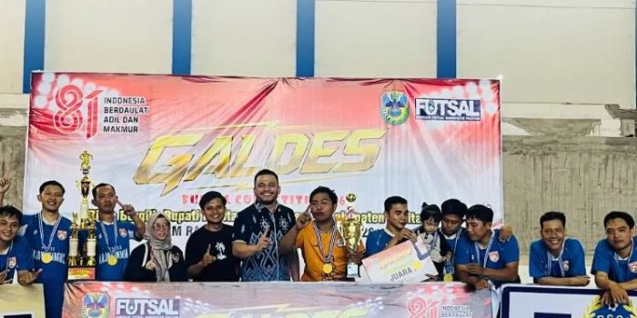 Tim futsal Desa Arjowinangun berpose bersama mengangkat trofi juara pertama Galdes Futsal Competition #6 2026 di Pacitan.