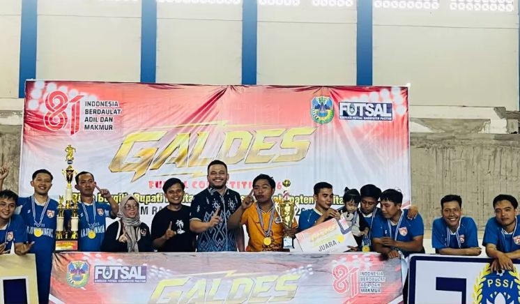 Tim futsal Desa Arjowinangun berpose bersama mengangkat trofi juara pertama Galdes Futsal Competition #6 2026 di Pacitan.