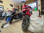 Barang Bukti Pencurian Umbi Porang Pacitan Foto barang bukti kasus pencurian umbi porang di Polres Pacitan. Di sebelah kanan, terlihat satu karung putih berisi umbi porang yang penuh dan sepeda motor Honda Beat warna hitam yang digunakan pelaku. Di area tengah, terdapat tas selempang, pisau, dompet, KTP, dan tumpukan nota penjualan porang yang tersusun rapi.