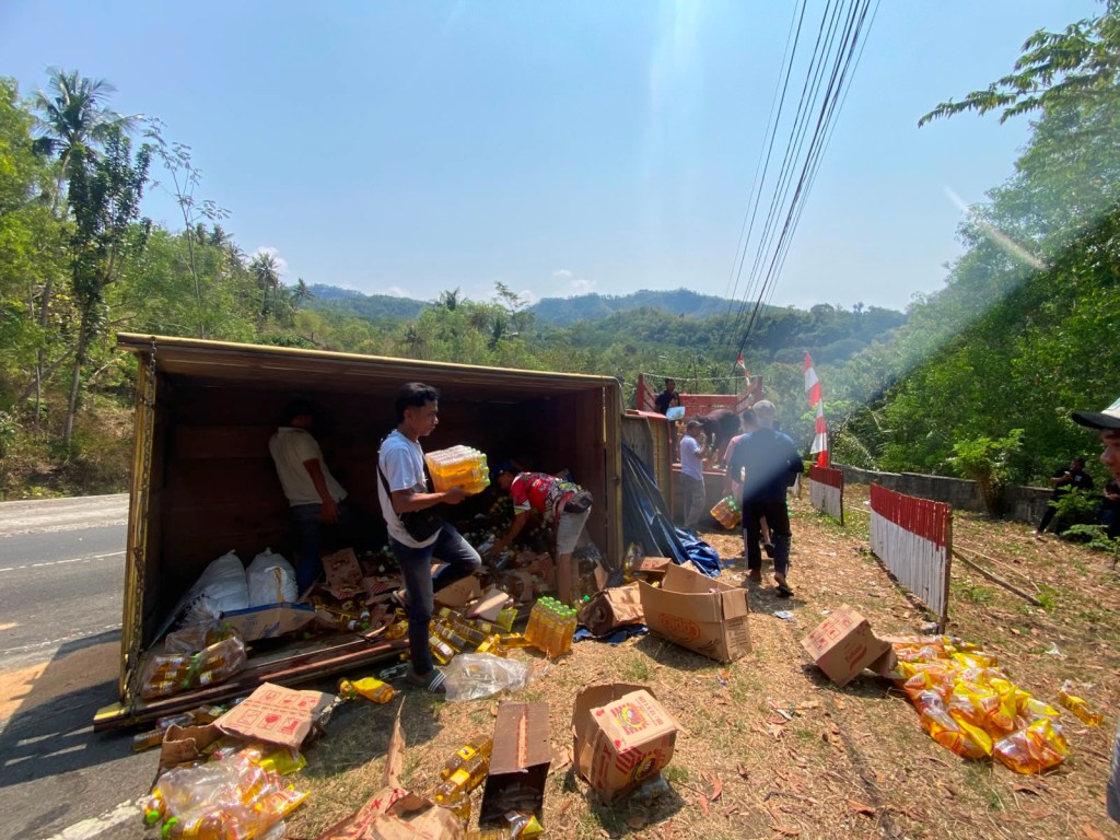 Proses evakuasi muatan kardus minyak goreng ke mobil cadangan pascakecelakaan truk engkel di Turunan Sedeng Pacitan.
