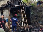 Petugas Damkar Pacitan melakukan pembasahan sisa kebakaran dapur rumah warga di Pringkuku