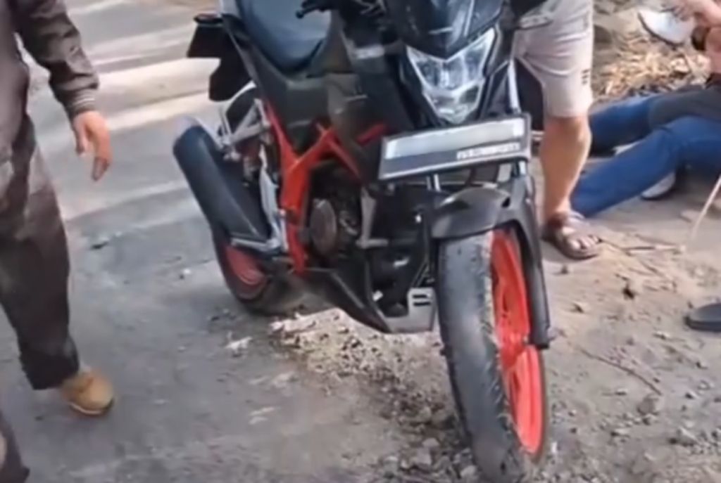 Ibu dan anak balita terjatuh dari motor akibat jalan berlubang dan rusak parah di tanjakan Sengkan Selang, jalur penghubung ekonomi Tegalombo Pacitan.