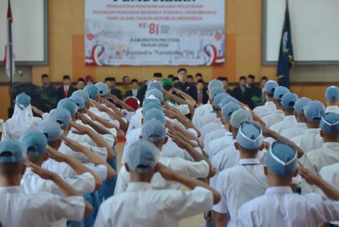 Pembukaan Karantina Paskibraka Pacitan 2026 Sekda Pacitan Heru Wiwoho menyematkan tanda peserta kepada anggota Paskibraka Pacitan 2026