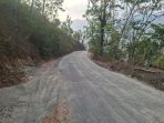 Permukaan aspal jalan Tegalombo-Tulakan hasil tambal sapu lubang dengan material sisa pasir yang berserakan.