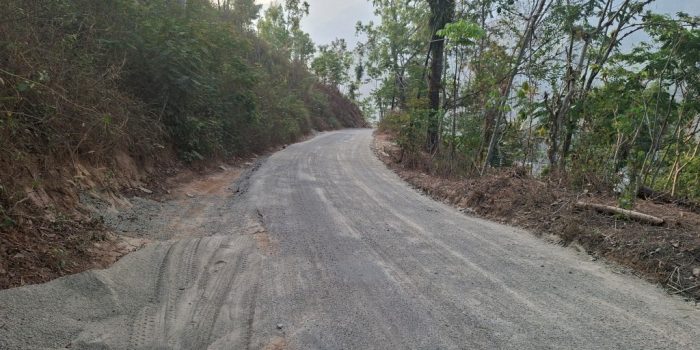 Permukaan aspal jalan Tegalombo-Tulakan hasil tambal sapu lubang dengan material sisa pasir yang berserakan.