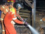 Petugas Damkar Pacitan melakukan pembasahan di lokasi kebakaran kandang sapi di Pringkuku.