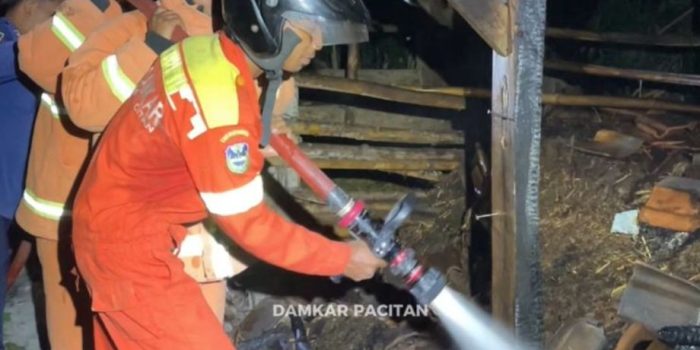 Petugas Damkar Pacitan melakukan pembasahan di lokasi kebakaran kandang sapi di Pringkuku.