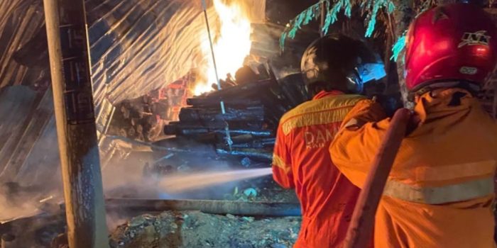 Petugas Damkar Pacitan melakukan pembasahan sisa kebakaran di pabrik kayu UD Manfaat Berkah Grup, Karangrejo.
