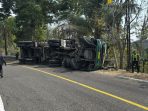 Truk Hino roda 14 warna hijau menabrak pembatas jalan di tikungan Jatisari Donorojo Pacitan.