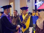 Direktur AKN Pacitan Prof. Joko Triyono menyalami wisudawan saat prosesi Wisuda XI Program D-2 di Auditorium Gedung B Kampus AKN Pacitan.