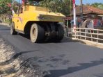 Pekerja menyelesaikan pengaspalan jalan di ruas Pringkuku-Poko Pacitan.