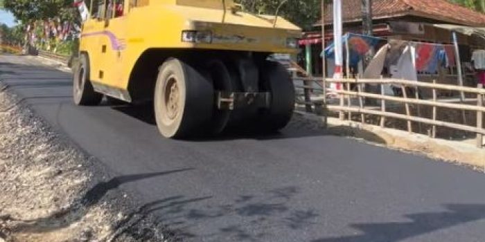 Pekerja menyelesaikan pengaspalan jalan di ruas Pringkuku-Poko Pacitan.
