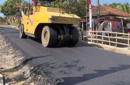 Progres Jalan Pringkuku-Poko Pacitan Pekerja menyelesaikan pengaspalan jalan di ruas Pringkuku-Poko Pacitan.