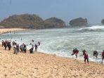 Wisatawan lari berhamburan saat gelombang tinggi tiba-tiba menerjang bibir Pantai Watukarung di Kabupaten Pacitan.