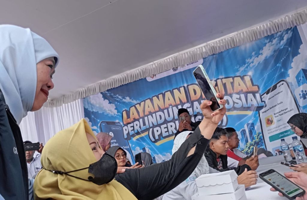 Gubernur Jatim Khofifah Indar Parawansa berswafoto bersama warga di stan Layanan Digital Perlindungan Sosial (Perlinsos) Kabupaten Pacitan.