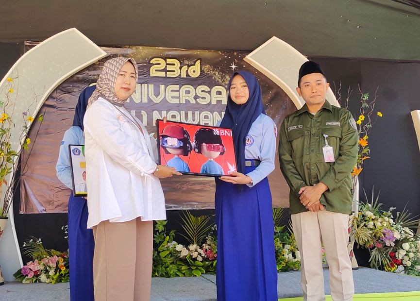 Perwakilan BNI Cabang Pacitan menyerahkan secara simbolis kartu pelajar digital kepada siswi didampingi Kepala SMKN 1 Nawangan Redy Yuniarto pada HUT ke-23 SMKN 1 Nawangan.
