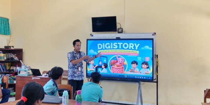 Guru SD Negeri Arjowinangun Pacitan Khrisna Adhi Pradana menjelaskan materi sistem pencernaan manusia melalui media interaktif DIGISTORY berbasis coding dan AI pada layar Interactive Flat Panel di depan siswa