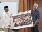 Sekda Pacitan Heru Wiwoho menyerahkan cendera mata Wayang Beber Pacitan kepada Asesor UNESCO Prof. Emeritus Dato’ Dr. Ibrahim Bin Komoo dalam evaluasi Geopark Gunung Sewu.