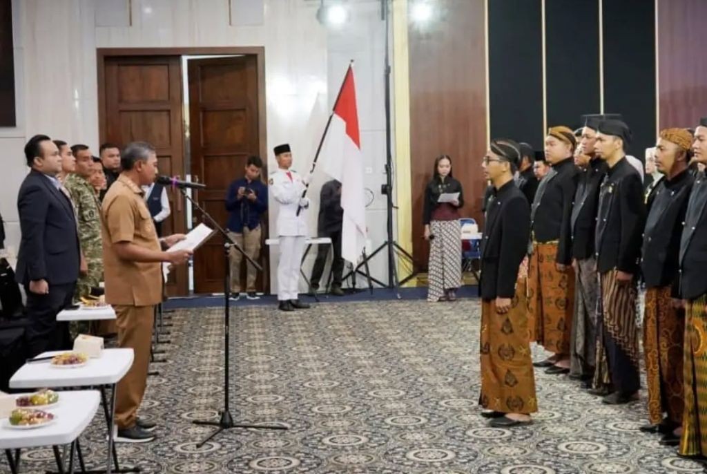 Prosesi Pengukuhan Pengurus Karang Taruna Kabupaten Pacitan Masa Bakti 2026–2031 Bupati Pacitan Indrata Nur Bayuaji membacakan naskah pengukuhan di hadapan jajaran pengurus Karang Taruna Kabupaten Pacitan masa bakti 2026–2031 yang mengenakan busana adat Jawa.