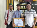 Siswa SMKN 1 Nawangan Pacitan, Regga Widi Adriansyah (tengah), memegang trofi dan piagam penghargaan Juara 1 FLS2N Tingkat Provinsi Jawa Timur 2026 didampingi dua guru pendamping di Pace Edotel SMKN 2 Pacitan.
