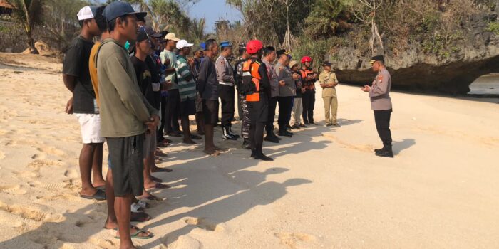 Anggota kepolisian, tim SAR gabungan, dan warga pesisir sedang memantau perairan dan menyisir area karang di Pantai Watu Murep, Pacitan, untuk mencari dua nelayan yang hilang.