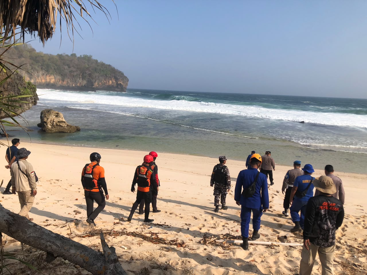 Anggota kepolisian, tim SAR gabungan, dan warga pesisir sedang memantau perairan dan menyisir area karang di Pantai Watu Murep, Pacitan, untuk mencari dua nelayan yang hilang.