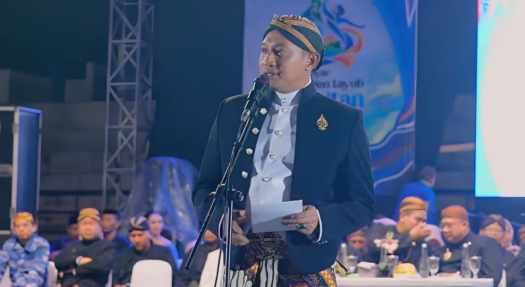 Bupati Pacitan Indrata Nurbayu Aji mengenakan beskap hitam dan blangkon saat menyampaikan sambutan dalam acara Gebyar Langen Tayub Pacitan 2026 pemecahan rekor MURI di Stadion Wijaya Krida.
