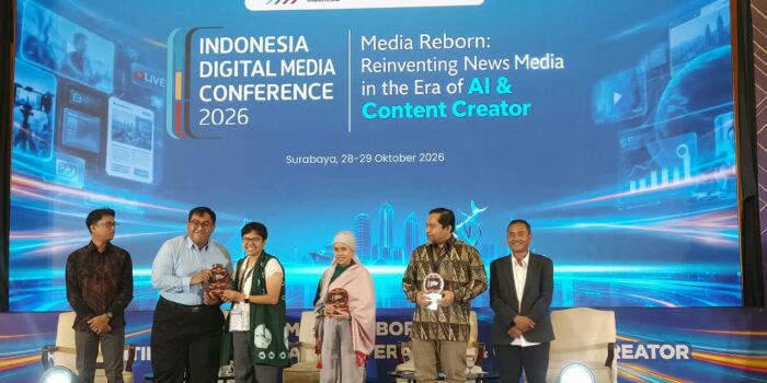 Para narasumber dan perwakilan Asosiasi Media Siber Indonesia berfoto bersama sambil memegang plakat di panggung Indonesia Digital Media Conference 2026, Surabaya.