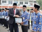 Wakil Bupati Pacitan Gagarin Sumrambah berjabat tangan dan menyerahkan sertifikat penghargaan Gema Bahana Nada kepada perwakilan ASN berseragam Korpri pada upacara Hari Sumpah Pemuda ke-98 di halaman Pendopo Kabupaten Pacitan.